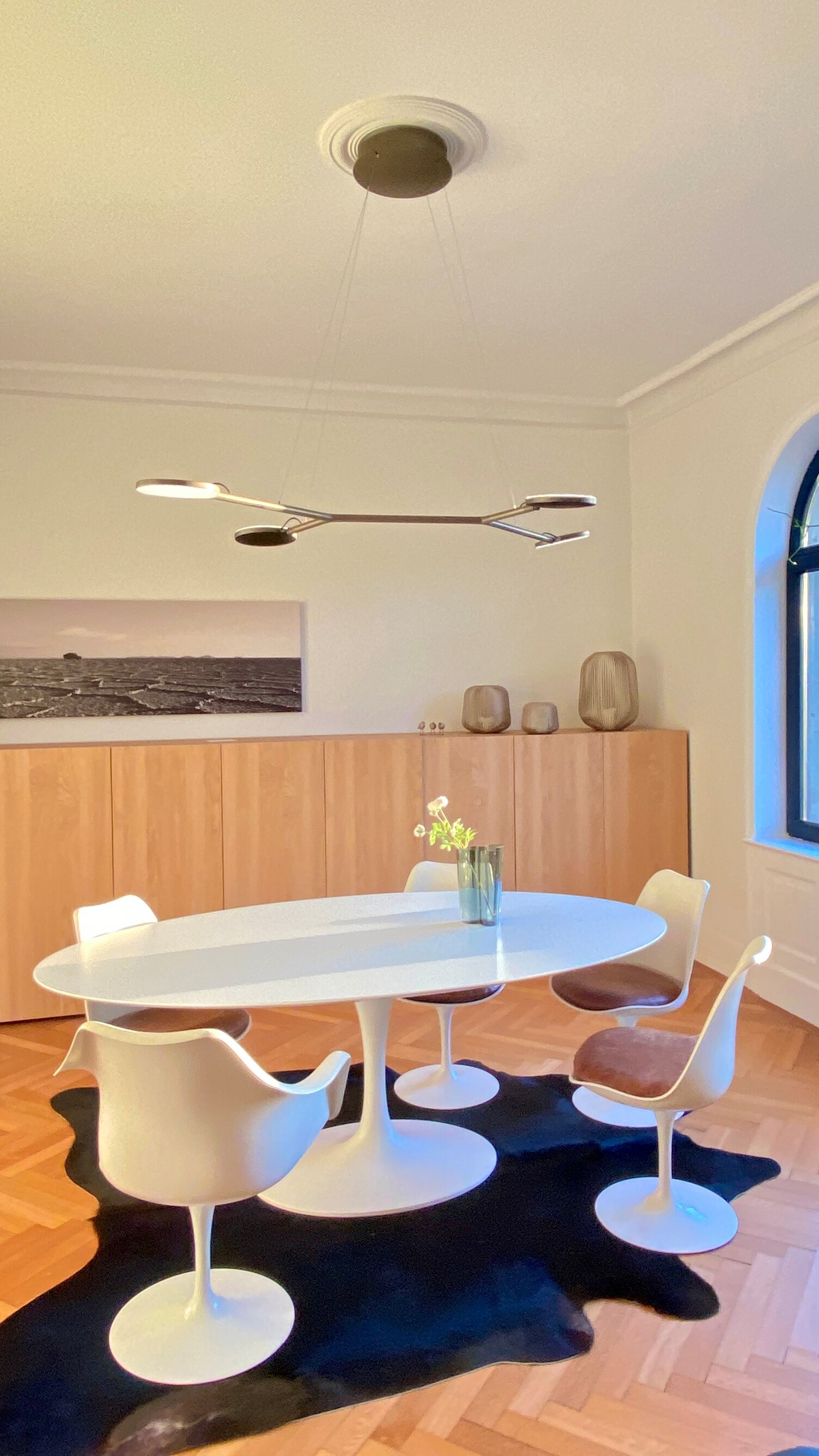 Pendelleuchte AVVENI Pendant 4 mit beweglichen Leuchtenköpfen in Sonderfarbe über modernen weißen Tisch. Köpfe sind abwechselnd nach oben zur Decke oder zum Tisch gedreht.