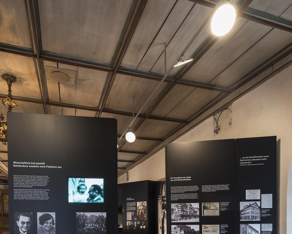 Ceiling-mounted track system lightlight + AVVENI | © Rose Hajdu, Stuttgart Flexible exhibit lighting with Lightlight surface-mounted track system + round AVVENI luminaire heads Historic building, Jewish Museum Göppingen, ceilings with wooden beams on which the Lightlight track lighting system with round, flat AVVENI luminaire heads can be seen, illuminating the pictorial history displays as museum lighting. | © Rose Hajdu, Stuttgart