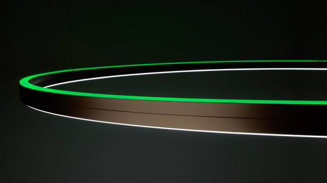 Ausschnitt der Aluminium-Ringleuchte Doppio direkt/indirekt mit RGB-Licht (grün) auf indirekter Seite.