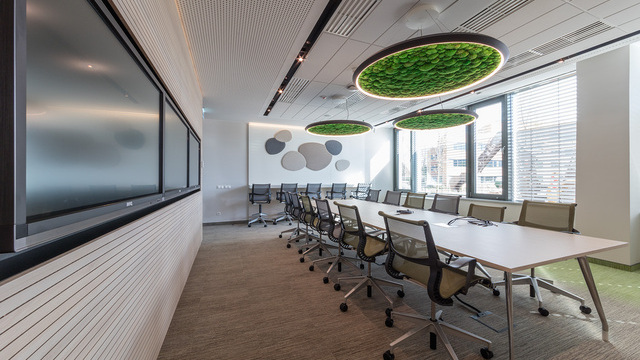 Innovative meeting room with green acoustic panels, natural lighting, and ergonomic furniture. | © Tamas Bujnovszky