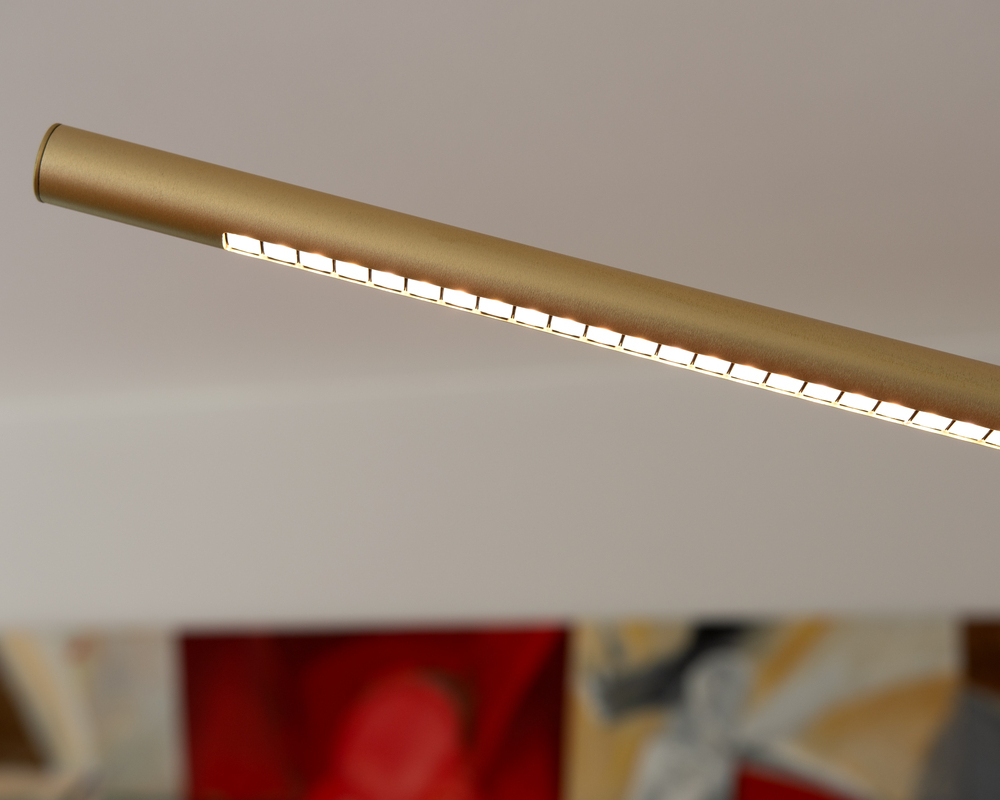 PALITO Linsentechnik | © Horst Mohring Detail der Stehleuchte PALITO zeigt oberen Bereich der zylindrischen Leuchte, mit gebogenem nach unten leuchtenden Bereich. Leuchtenfarbe Champagner Gold, Lichtbereich besteht aus aneinandergereihten viereckigen Linsen. | © Horst Mohring