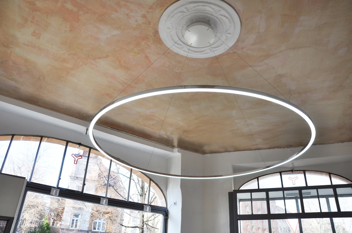 Optional: current carrying suspension Slender ring pendant luminaire (SLIM DIRECT) attached to a canopy on a stucco ceiling. The luminaire appears to float in the room due to the thin current-carrying suspension.
