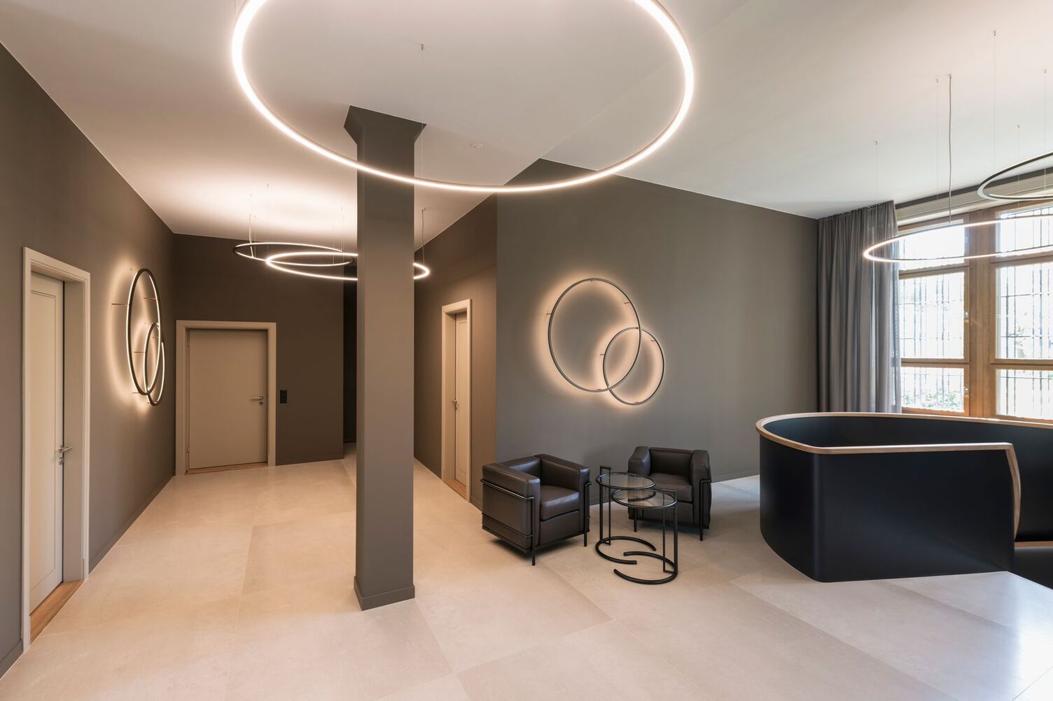 © Andreas Zimmermann Fotografie Im obersten Bereich eines Treppenhauses einer Bank, welcher Zugleich als Wartebereich dient wurden stilgerecht mit bronzefarbenen Slim direkt, Slim indirekt, sowie Slim Wall Leuchten in verschiedenen Leuchtendurchmessern ein Beleuchtungsambiente geschaffen, was die Raumausleuchtung, Akzentbeleuchtung der Wände, sowie ein harmonisches Ambiente im Wartebereich erzeugt. Ebenso wird der Raum nach oben hin aufgeweitet durch unsere indirekte Deckenbeleuchtung aus dem Hause SATTLER, welches das historische Gebäude der Bank aufwertet. | © Andreas Zimmermann Fotografie
