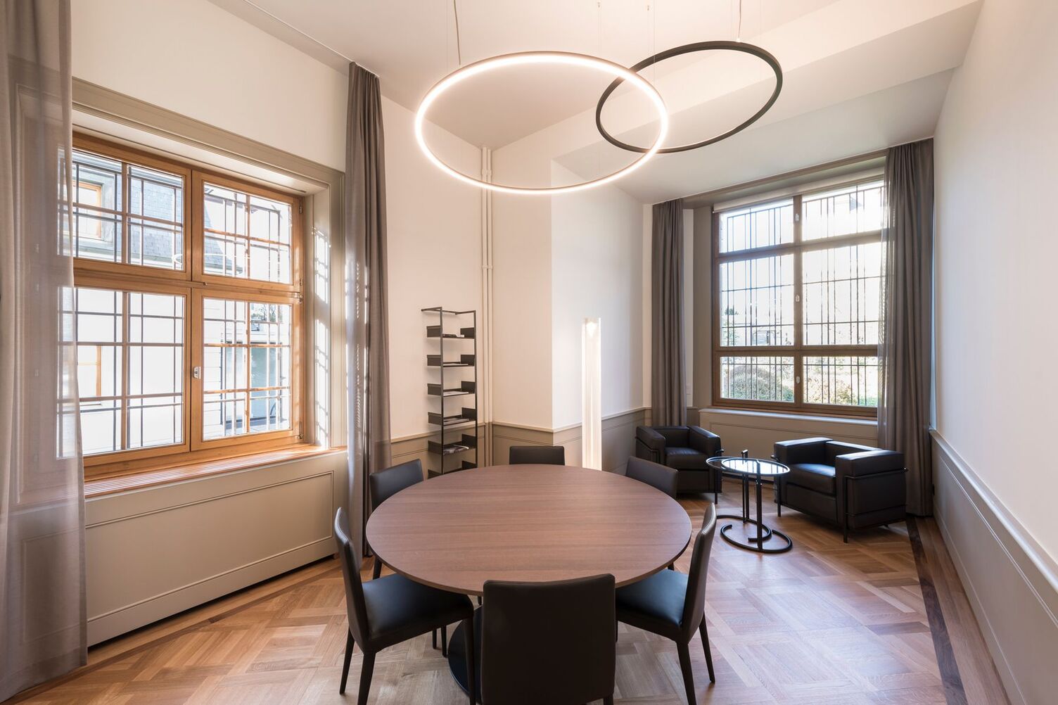 © Andreas Zimmermann Fotografie Runde Besprechungsinsel in einem Besprechungsraum mit darüber angeordneten Slim direkt sowie Slim indirekt in bronze satiniert in einem historischen Gebäude einer Bank | © Andreas Zimmermann Fotografie