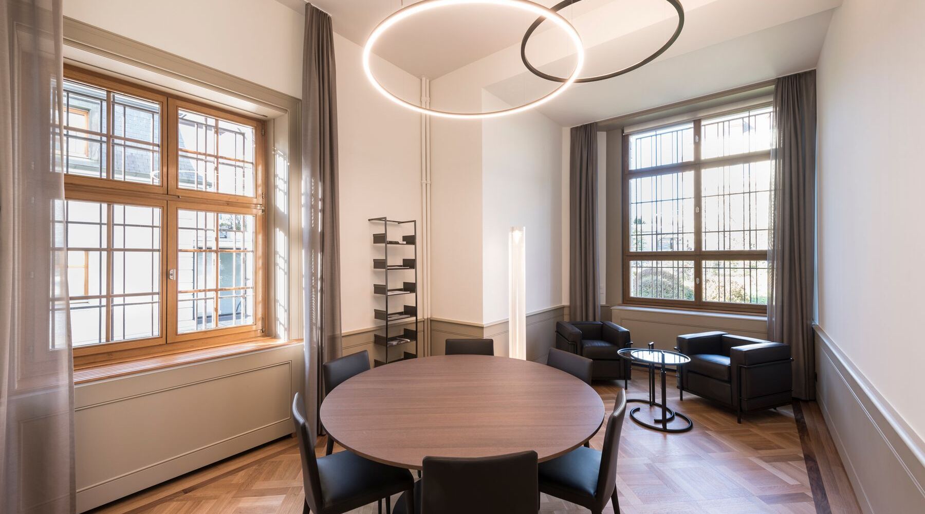 © Andreas Zimmermann Fotografie Runde Besprechungsinsel in einem Besprechungsraum mit darüber angeordneten Slim direkt sowie Slim indirekt in bronze satiniert in einem historischen Gebäude einer Bank | © Andreas Zimmermann Fotografie