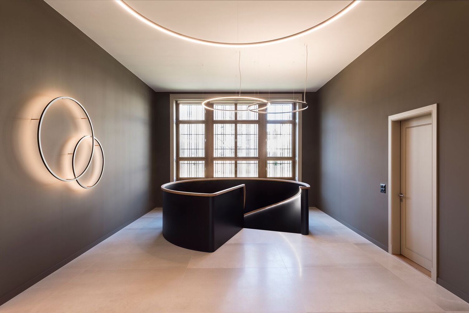 In a historic bank building, Slim Wall luminaires in various diameters were used to create accent lighting and the ceiling height was extended using indirect SLIM luminaires. The SLIM provides direct lighting to illuminate the basic lighting in the corridor area.