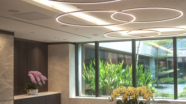 Five filigree SLIM DIRECT LED ring lights in Special Bronze Varnish by SATTLER suspended above a premium marble table at Changi Airport, providing direct illumination with refined architectural presence. | © Technolite