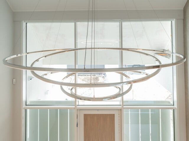 Lampe Treppenhaus/ Kronleuchter für Eingangsbereich: Seitenanblick auf die TOCCATA, einen modernen Kronleuchter bestehend aus mehreren verbunden einzelnen Ringleuchten, welche eine umgekehrte Pyramidenform ergibt. | © Luminarium