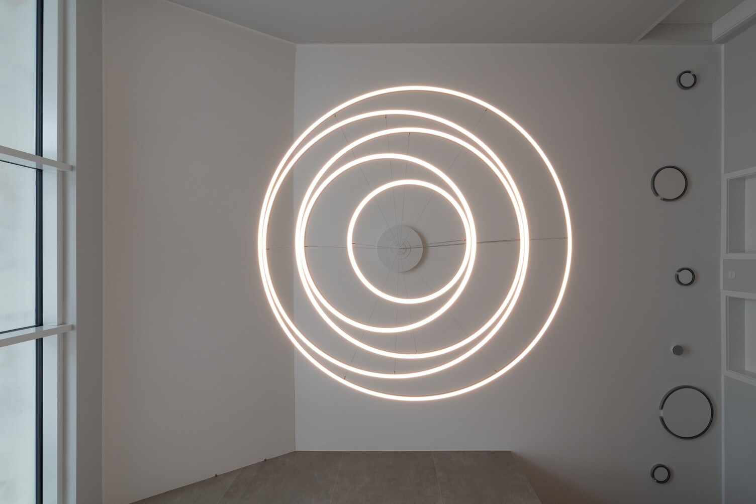 View from below onto the ceiling of a modern chandelier consisting of several light rings that form a spiral shape: the TOCCATA 1900 pendant light.