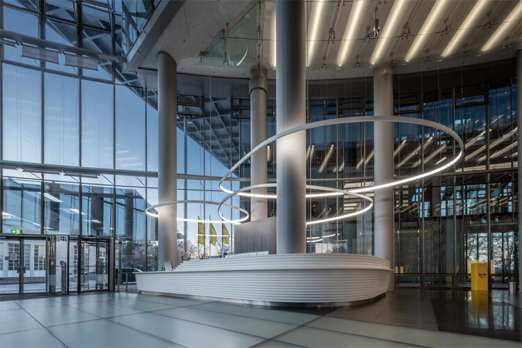 custom luminaires ring lights installed around columns in atrium of office building