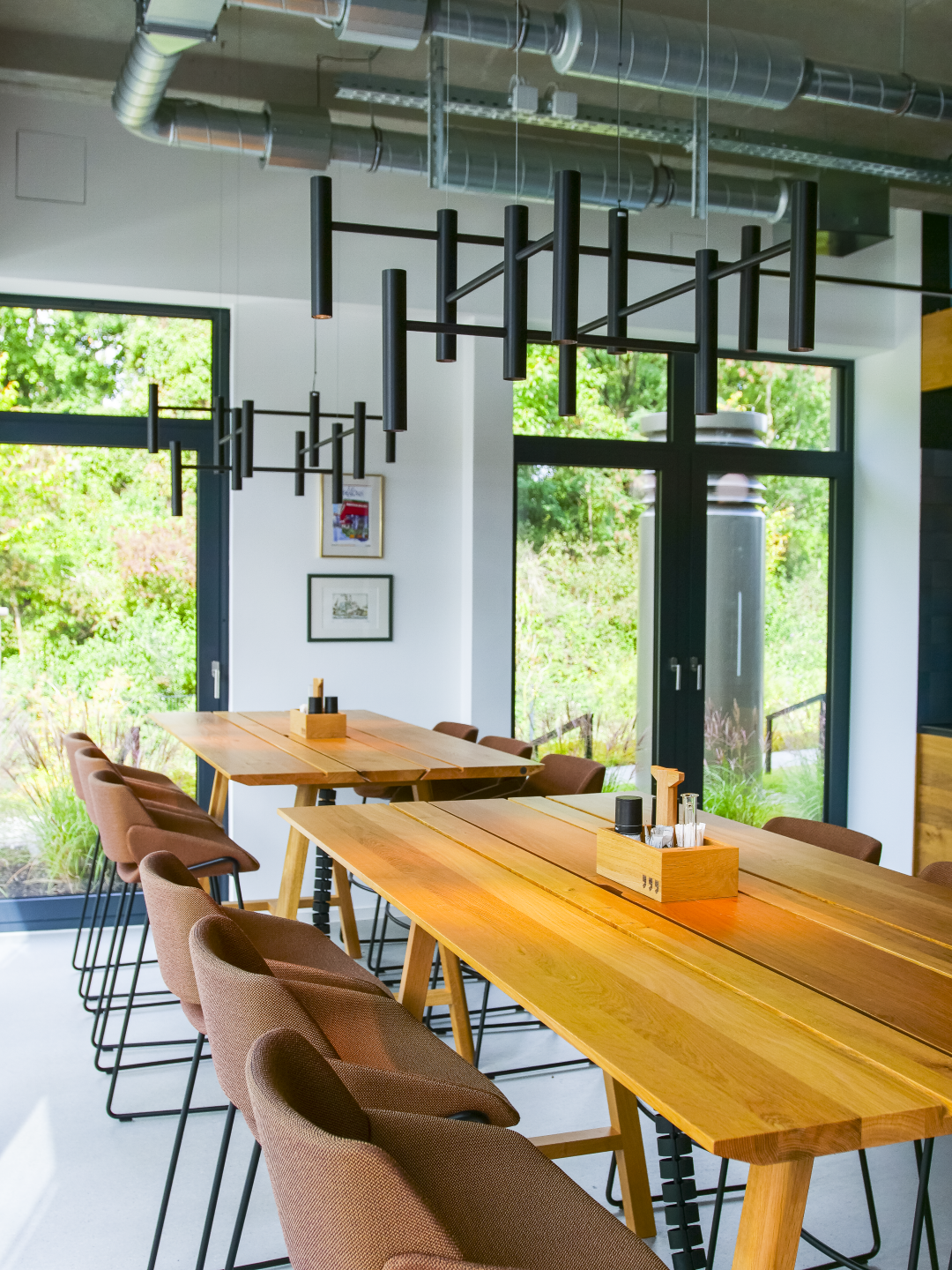 EVOLUTION S in der Cafeteria Cafeteria bei DAHLHAUSEN Medizintechnik mit EVOLUTION S Kronleuchter-Pendelleuchte in schwarzer Sonderfarbe.