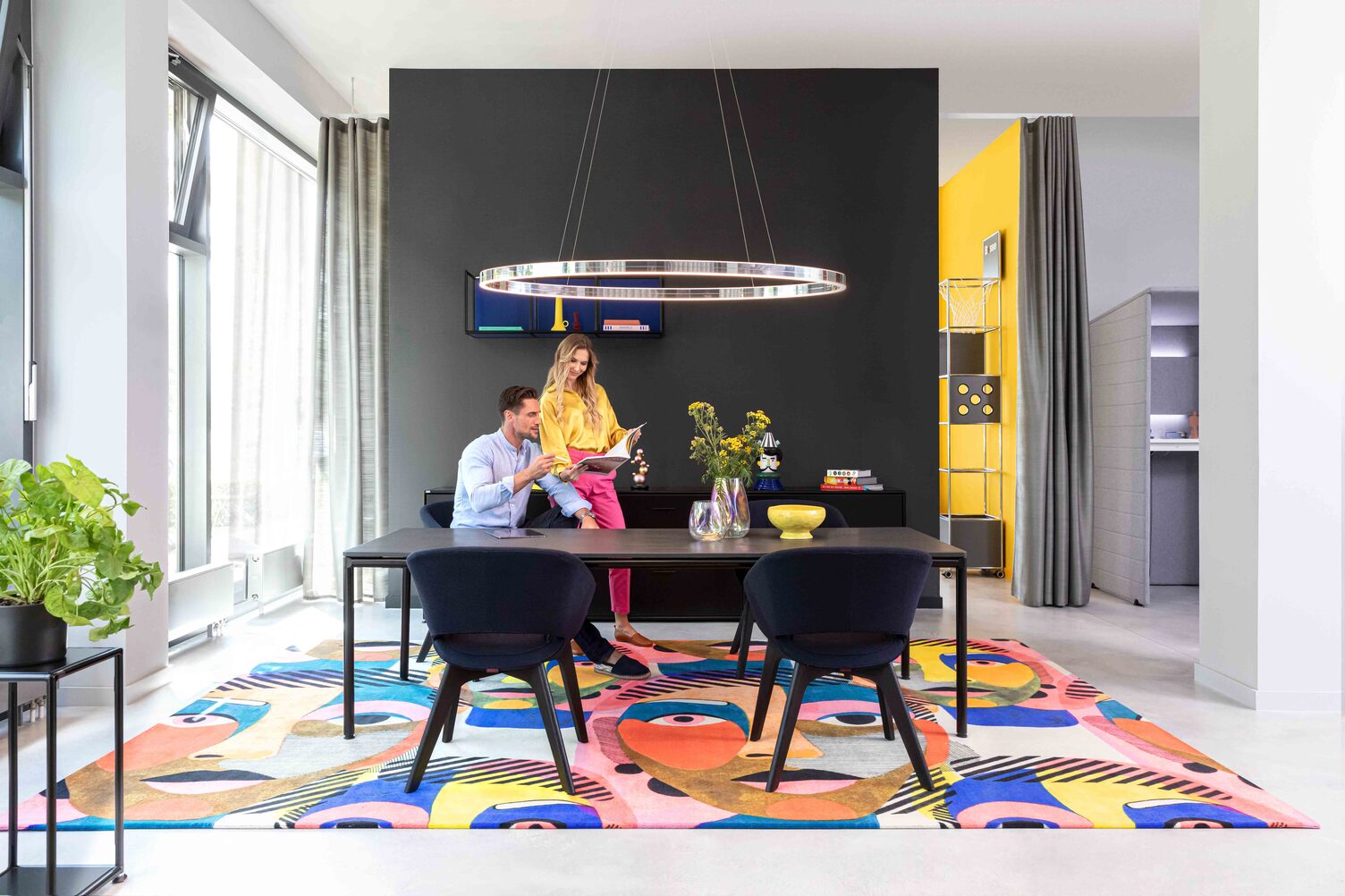 Modern showroom with a colorful rug and stylish lighting in Offenbach, featuring Sattler's Doppio Ellipse lighting."