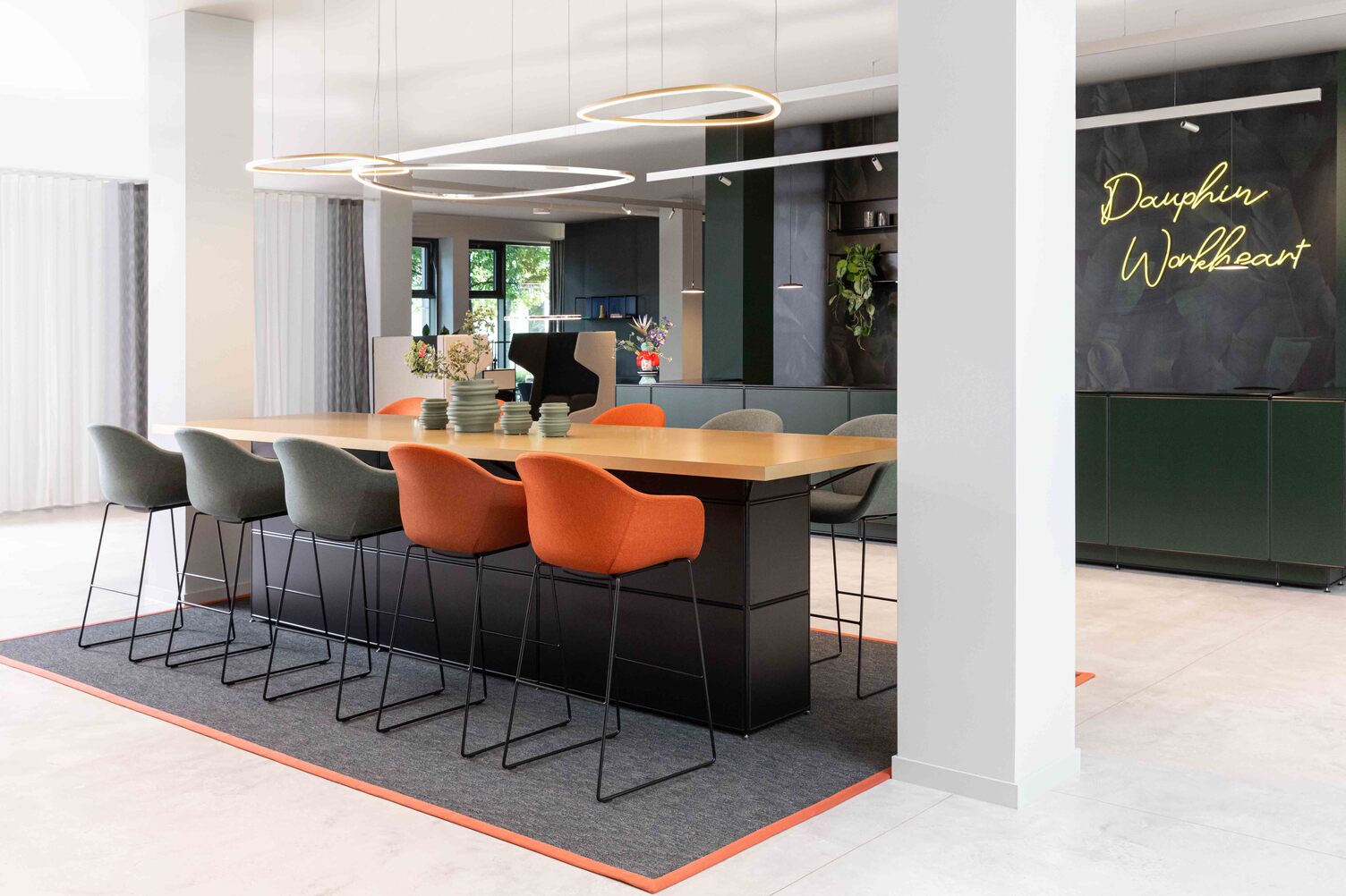 Meeting point with Slim Delta Direct luminaires from SATTLER. In the background, a reception desk with Paladio System Track luminaire and Paladio System LENS, each installed as a pendant version at different heights. Avveni Pendant 1 and Evo Spot were also used in the Track luminaire