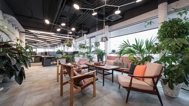 Two AVVENI PENDANT 5 branched white pendant lights with round flat light heads float above the cosy meeting and lounge area with 1960s furniture in the Dealogic Orangery, creating flexible lighting accents. | ©  Krisztina Filep