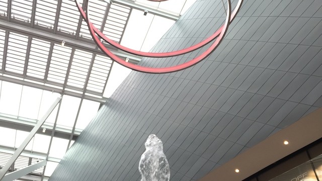 Wasserspringbrunnen in Shopping Mall, darüber ein Lichtobjekt aus mehreren Ringleuchten (CIRCOLO) übereinander. 