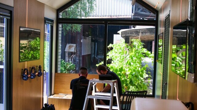 Two craftsmen working on the interior of a tiny house with modern lighting. | © Alexander Strifler