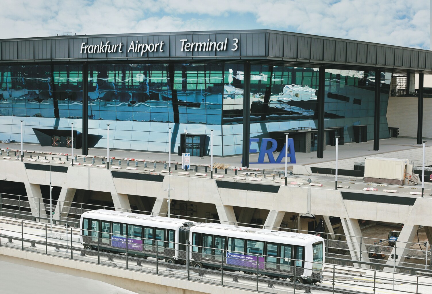 Außenansicht mehrstöckiger Terminal 3 des Frankfurter Flughafens mit der Sky-Line-Station/-Bahn vor dem Gebäudetrakt. | © Fraport