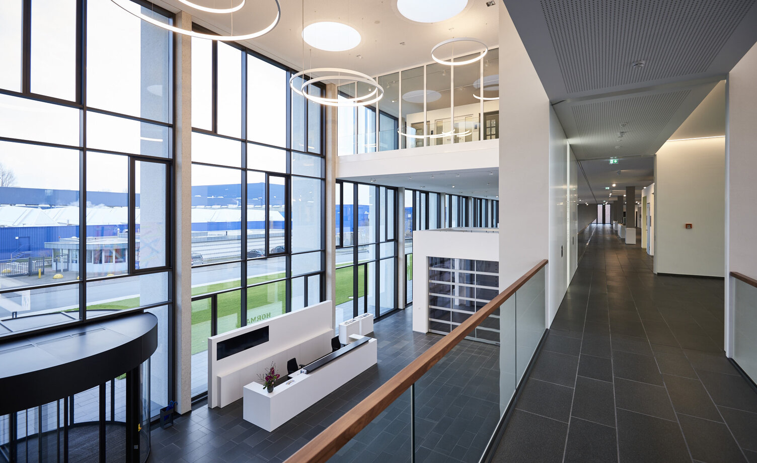 Blick auf die SATTLER CIRCOLO in einer Lobby auf Stockwerkshöhe | © Architekten Wannenmacher + Möller GmbH Blick auf die Leuchten CIRCOLO der Firma SATTLER in verschiedenen Durchmessern, von einem Stockwerk aus in Richtung Empfang fotografiert | © Architekten Wannenmacher + Möller GmbH