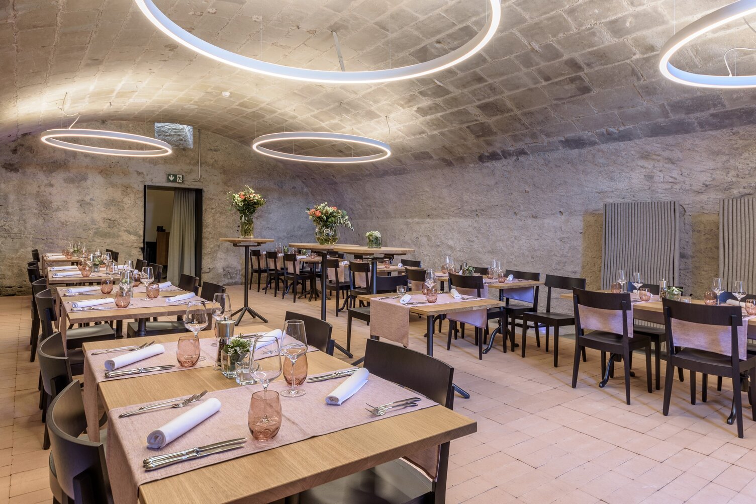 Ringleuchten DUETTO im Restaurant Hirschenbad - Gewölbekeller | © LUXED Einladender Restaurantraum im Hirschenbad Langenthal, im hellen Gewölbekeller, erleuchtet von großen schmalen weißen Ringleuchten (DUETTO) , die direkt und indirekt leuchten. | © LUXED
