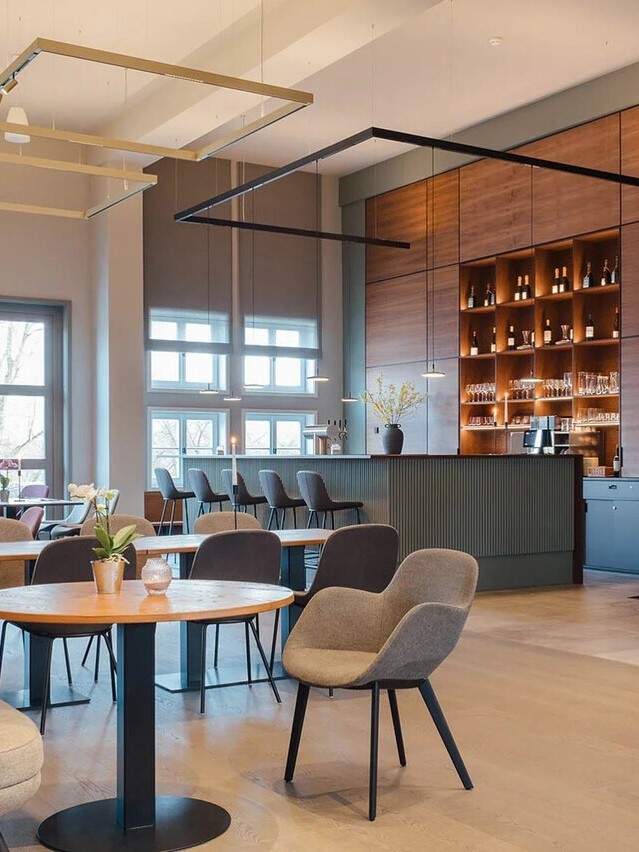 Hotelrestaurant und Bar im Nattika Ayurveda Hotel in Berlin Alt Rhese "Park am See". Beleuchtung mittels Systemleuchten der PALADIO Serie als Quadrate abgependelt mit EVOLUTION SPOTS und als offenes Hufeisen über der Bar abgependelt mit den AVVENI PENDANT 1 Pendelleuchten. | © https://www.cremeguides.com/berlin/retreat-park-am-see-nattika-ayurveda/