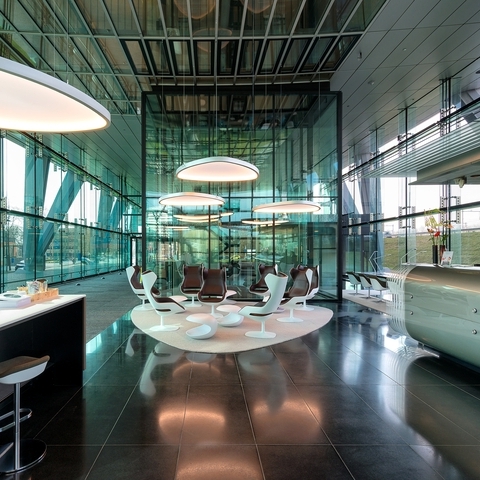 Fabric-covered Soft Delta Light & Acoustic luminaires from SATTLER in a modern glass lobby with reception and cafeteria