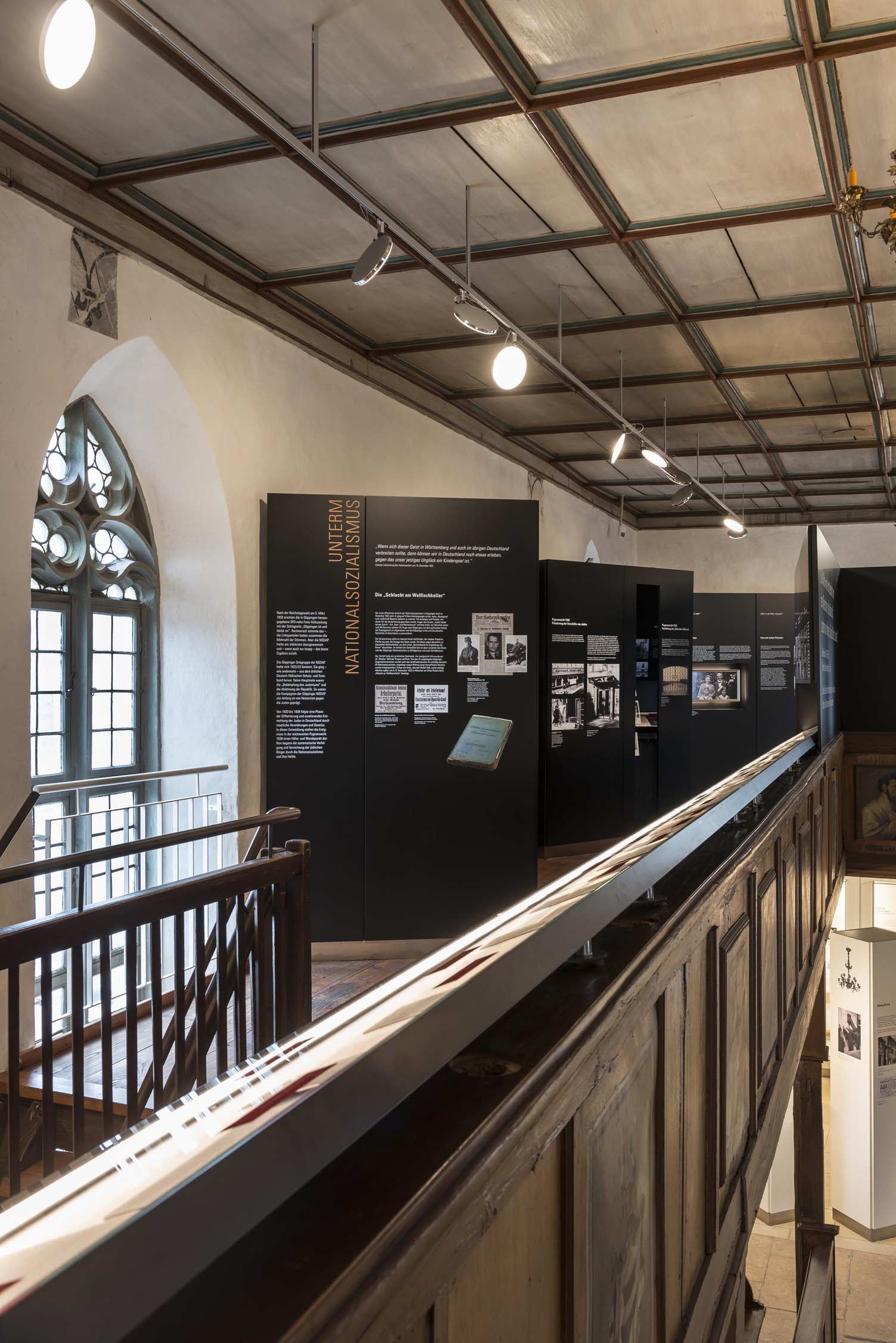 Museumsausstellung in dunkler Holzumgebung. Schwarze Info-Tafeln und auch bauliche Stilelemente wie alte Kronleuchter werden von flexibel ausrichtbaren runden Leuchtköpfen der AVVENI ausgeleuchtet. | © Rose Hajdu, Stuttgart