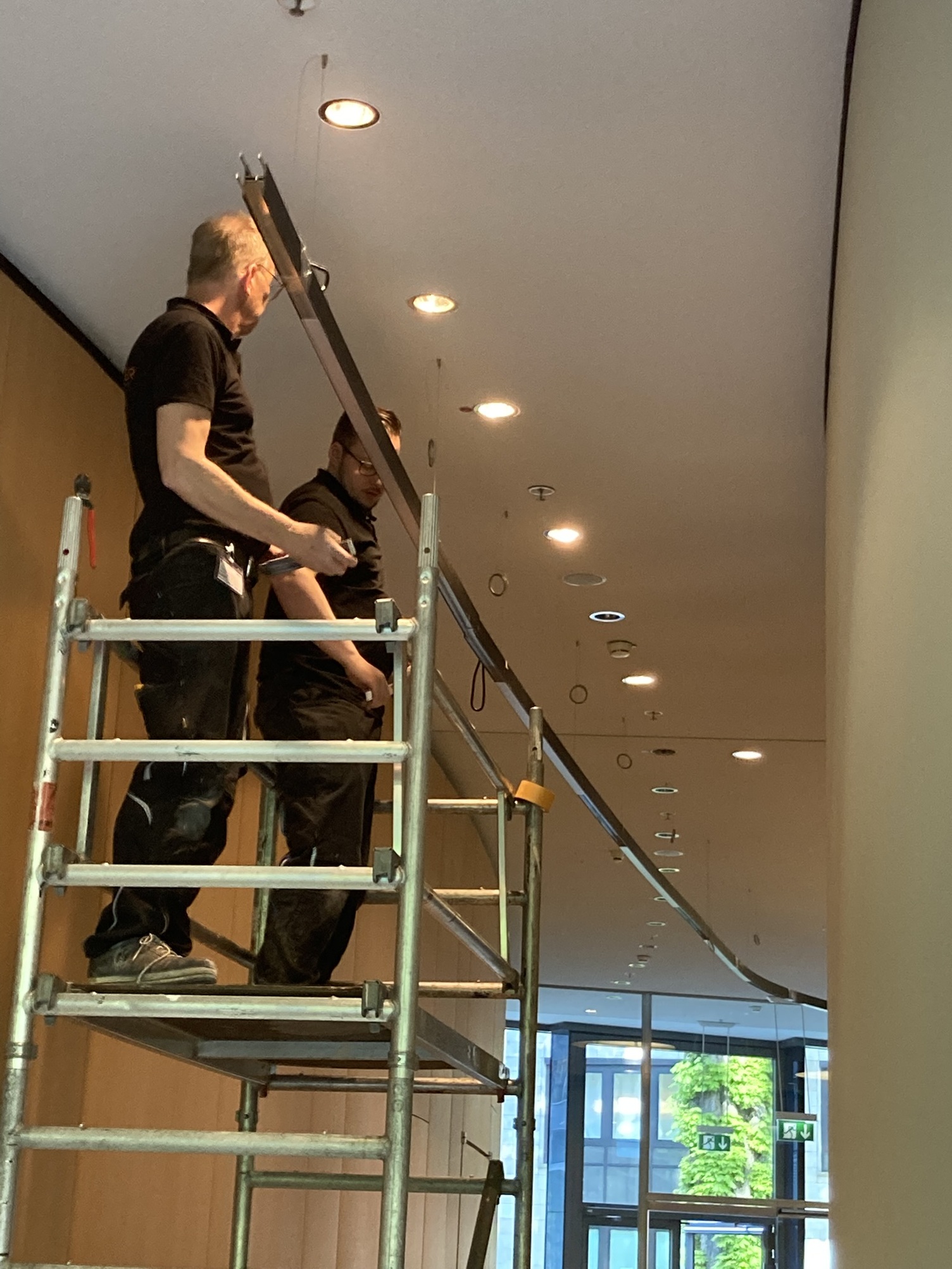 SATTLER Montageteam Zwei SATTLER Monteure auf Gerüst zur Leuchtenmontage einer DUETTO Lichtlinie.