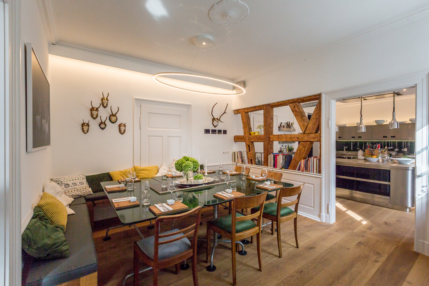  Large, elliptical SLIM ELLIPSE pendant light by SATTLER hovers over an elegantly set dining table in Andrea Lange Cooking School.