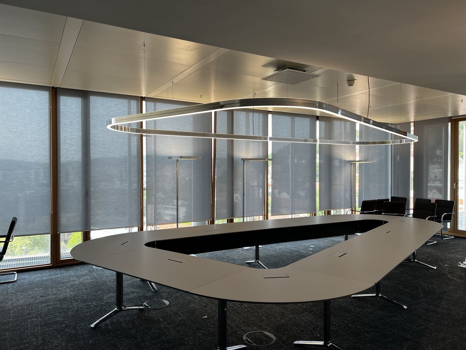 Delta-shaped conference table in the LBBW Stuttgart with customised DUETTO ring light, perfectly adapted to the delta shape of the table