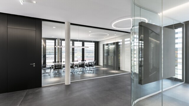 corridor area with a Slim arranged directly. In the glass office behind, a Doppio Ellipse was suspended above a meeting table. | © SATTLER | Nikolay Kazakov niko design