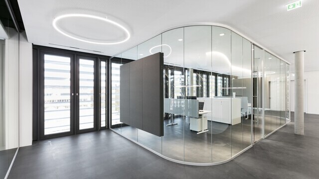 Slim Direkt from SATTLER mounted directly to the ceiling in a corridor. In the background are glass offices with SATTLER Doppio ellipses and BE spotlights.  | © SATTLER | Nikolay Kazakov niko design