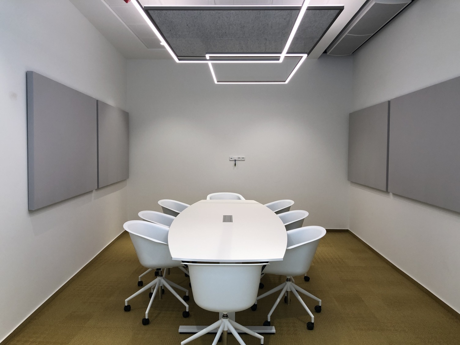 Besprechungsraum mit GIOCO Acoustic Leuchten und akustischen Wandpaneelen zur Verbesserung der Raumakustik von SATTLER
