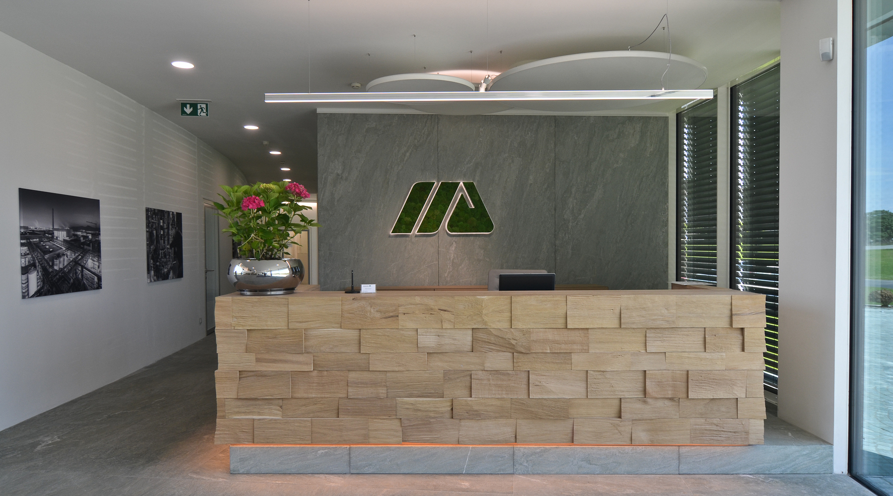 SATTLER Doppio Linea in aluminium poliert in Kombination mit Akustik Panel, sowie Moos Sonderleuchten Logo | © SATTLER | Werbe-und Medienagentur Mohring Empfangstheke mit einer Doppio Linea in Alumiminium poliert. Im Hintergrund sind zusätzlich Akustik Panele, sowie eine Moos Leuchte als Firmenlogo in Sonderausführung an der Wand, alles jeweils von Firma SATTLER angebracht. | © SATTLER | Werbe-und Medienagentur Mohring