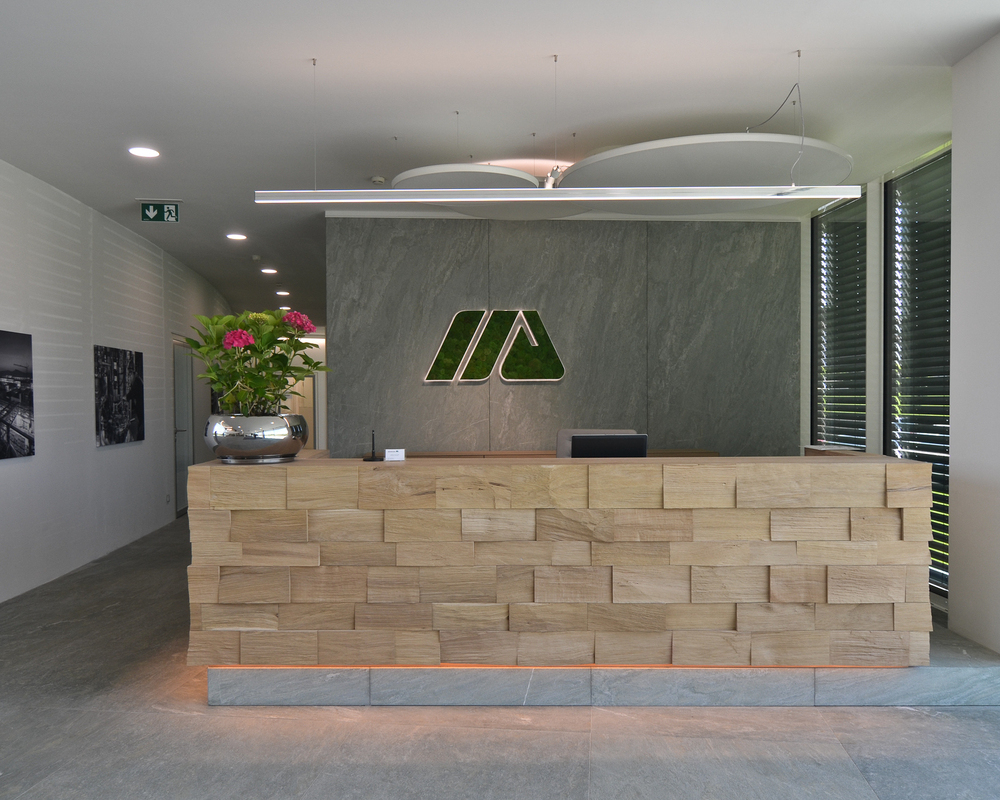 SATTLER Doppio Linea in aluminium poliert in Kombination mit Akustik Panel, sowie Moos Sonderleuchten Logo | © SATTLER | Werbe-und Medienagentur Mohring Empfangstheke mit einer Doppio Linea in Alumiminium poliert. Im Hintergrund sind zusätzlich Akustik Panele, sowie eine Moos Leuchte als Firmenlogo in Sonderausführung an der Wand, alles jeweils von Firma SATTLER angebracht. | © SATTLER | Werbe-und Medienagentur Mohring