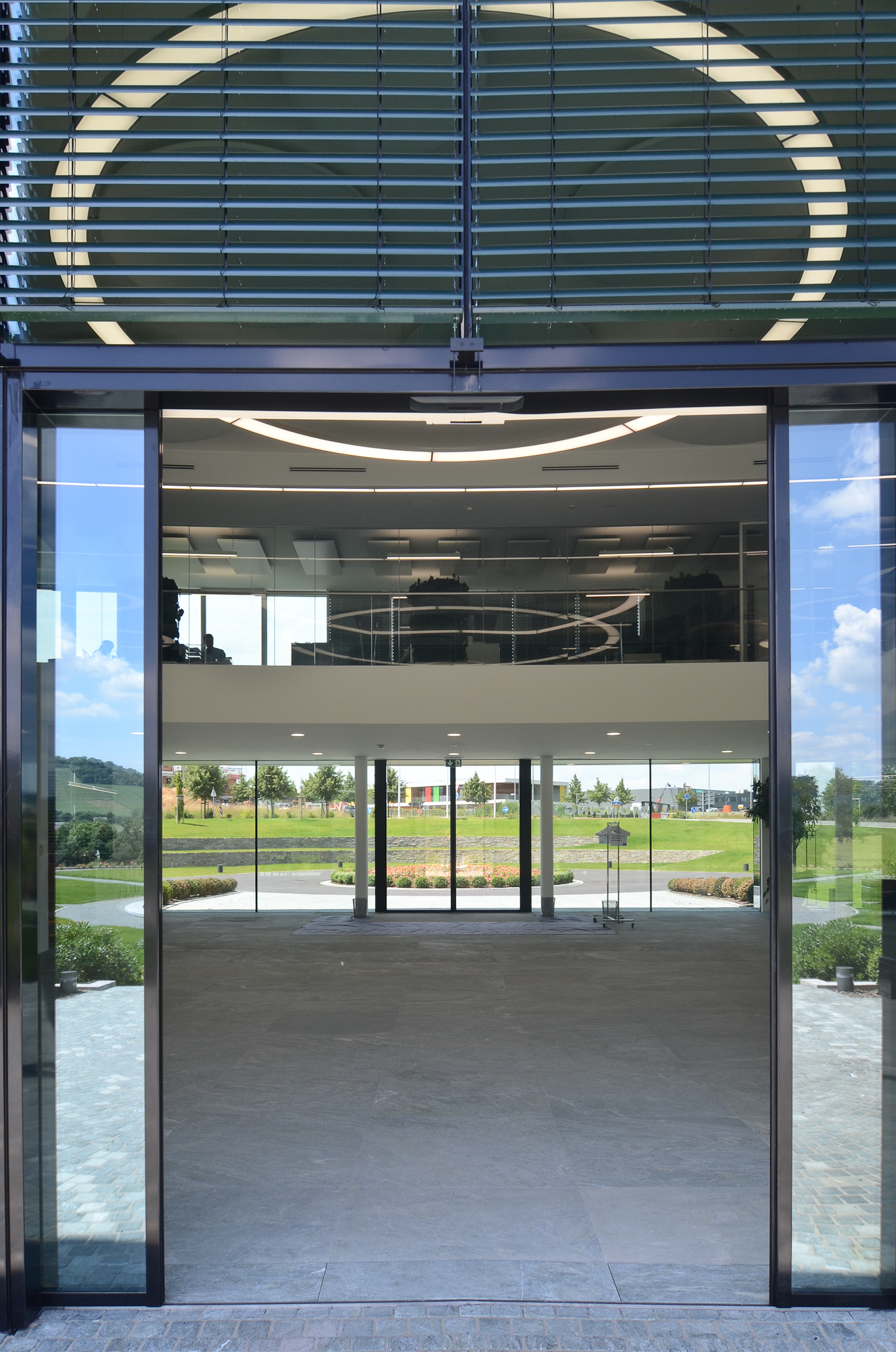 Von außen durch den Eingang in ein Foyer fotografiert. Zu sehen ist eine Anello 6m Durchmesser von SATTLER im inneren des Gebäudes.