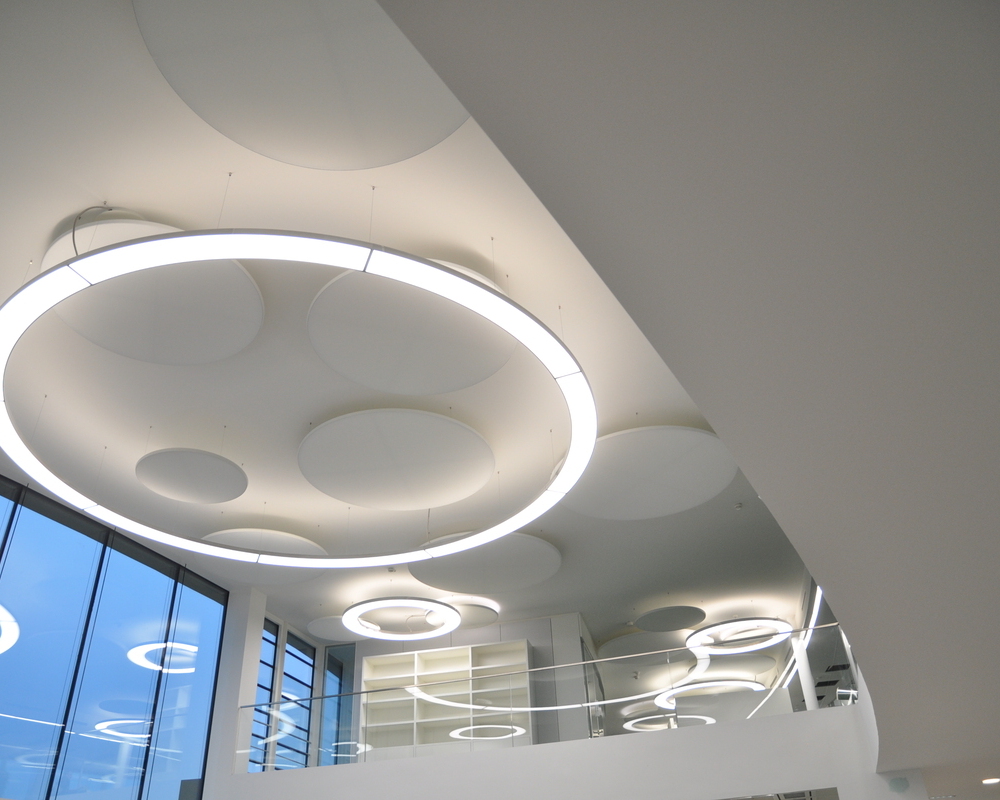 Runde Pendelleuchte Anello 6m und Acoustic Panel im Foyer der Münzing Chemie | © SATTLER | Werbe-und Medienagentur Mohring In einem Foyer mit Blick in Richtung einer 6m Anello in Aluminium poliert und parallel dazu montierten Akustik Panel jeweils von SATTLER. | © SATTLER | Werbe-und Medienagentur Mohring