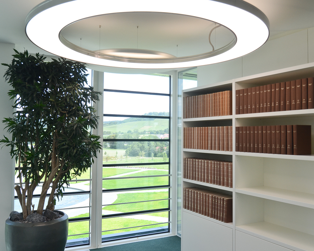 Anello 2m + Acoustic Panel jeweils von SATTLER in Büroverkehrsfläche in Alumimium poliert | © SATTLER | Werbe-und Medienagentur Mohring In einer Büroverkehrsfläche mit Bücherregal im Hintergrund wurde esthetisch eine Anello im Durchmesser 2m in Aluminium poliert in Kombination mit Acoustic Panels jeweils von SATTLER eingesetzt. | © SATTLER | Werbe-und Medienagentur Mohring