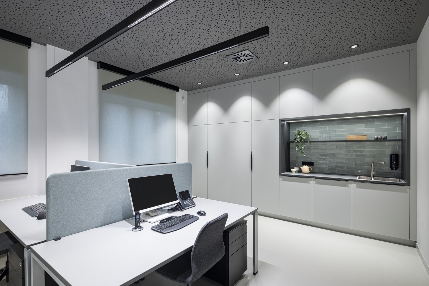 Bildschirmarbeitsplatz mit blendfreien PALADIO LENS Linearleuchten Dreier Arbeitsplatz mit zwei PALADIO LENS Linearleuchten über den Schreibtischen und BE Downlights an der Decke am Rand als Grundbeleuchtung und um die umliegenden Wände bzw. Schränke auszuleuchten.