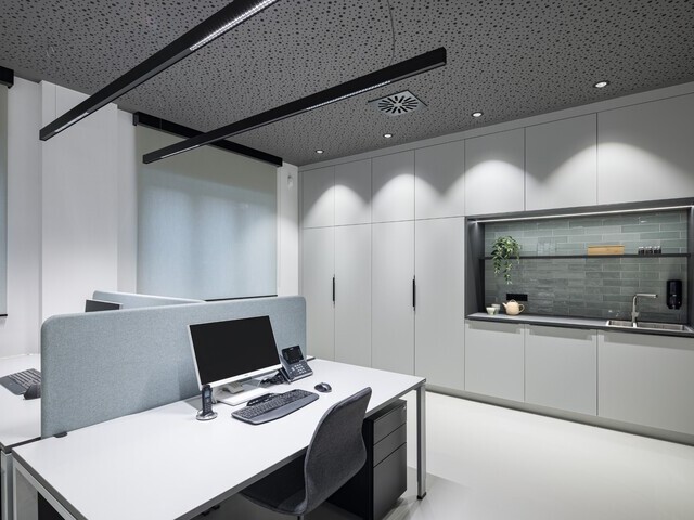 Dreier Arbeitsplatz mit zwei PALADIO LENS Linearleuchten über den Schreibtischen und BE Downlights an der Decke am Rand als Grundbeleuchtung und um die umliegenden Wände bzw. Schränke auszuleuchten. | © Lars Gruber