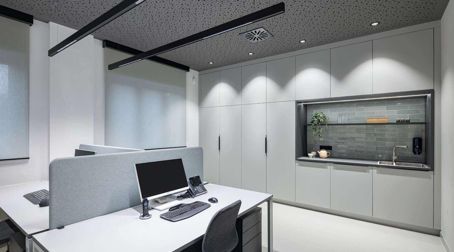 Bildschirmarbeitsplatz mit blendfreien PALADIO LENS Linearleuchten Dreier Arbeitsplatz mit zwei PALADIO LENS Linearleuchten über den Schreibtischen und BE Downlights an der Decke am Rand als Grundbeleuchtung und um die umliegenden Wände bzw. Schränke auszuleuchten.