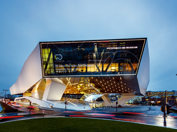 Full view of the Porsche Museum building in Stuttgart with dynamic evening lighting by Sattler. | © Tobias Fröhner Photography