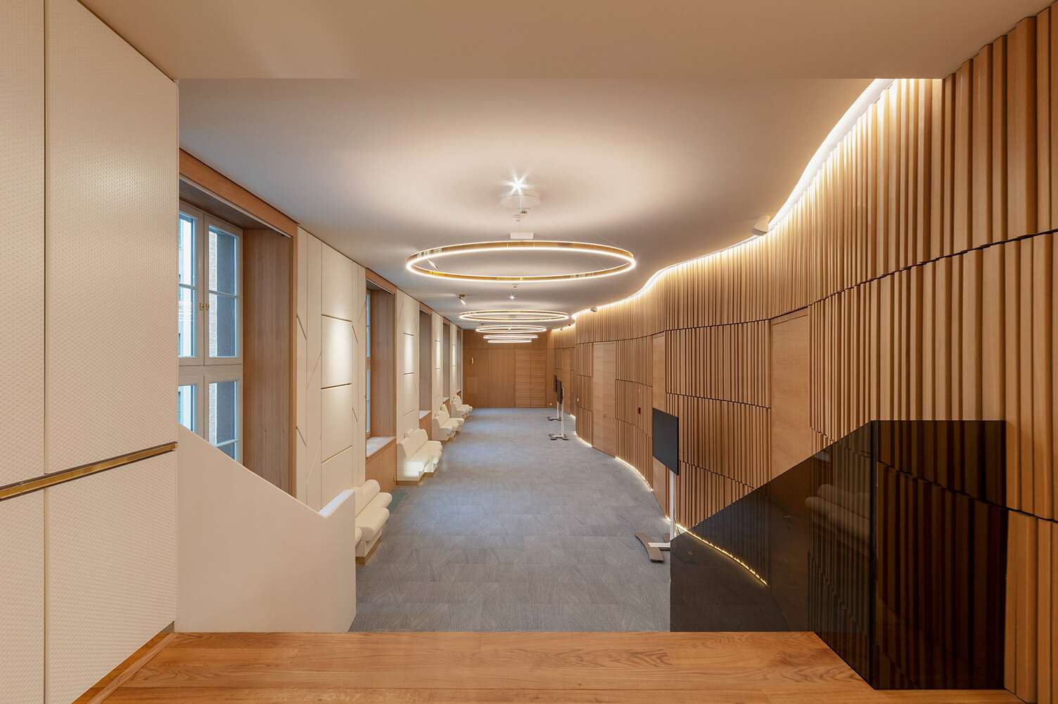 Elegant hallway in the Postpalast, Budapest, featuring wooden paneling and Sattler's Doppio lighting fixtures.