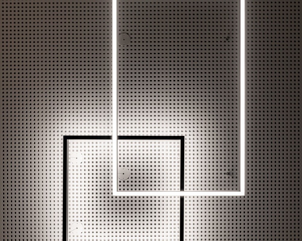Square frame lamp with direct or indirect lighting | © ARCHITEKTURIMBILD, Bernhard Tränkle View from below of a perforated ceiling from which two square LED lights (GIOCO) are suspended. A square black frame light provides indirect lighting and illuminates the ceiling, while a rectangular light shines directly downwards. | © ARCHITEKTURIMBILD, Bernhard Tränkle