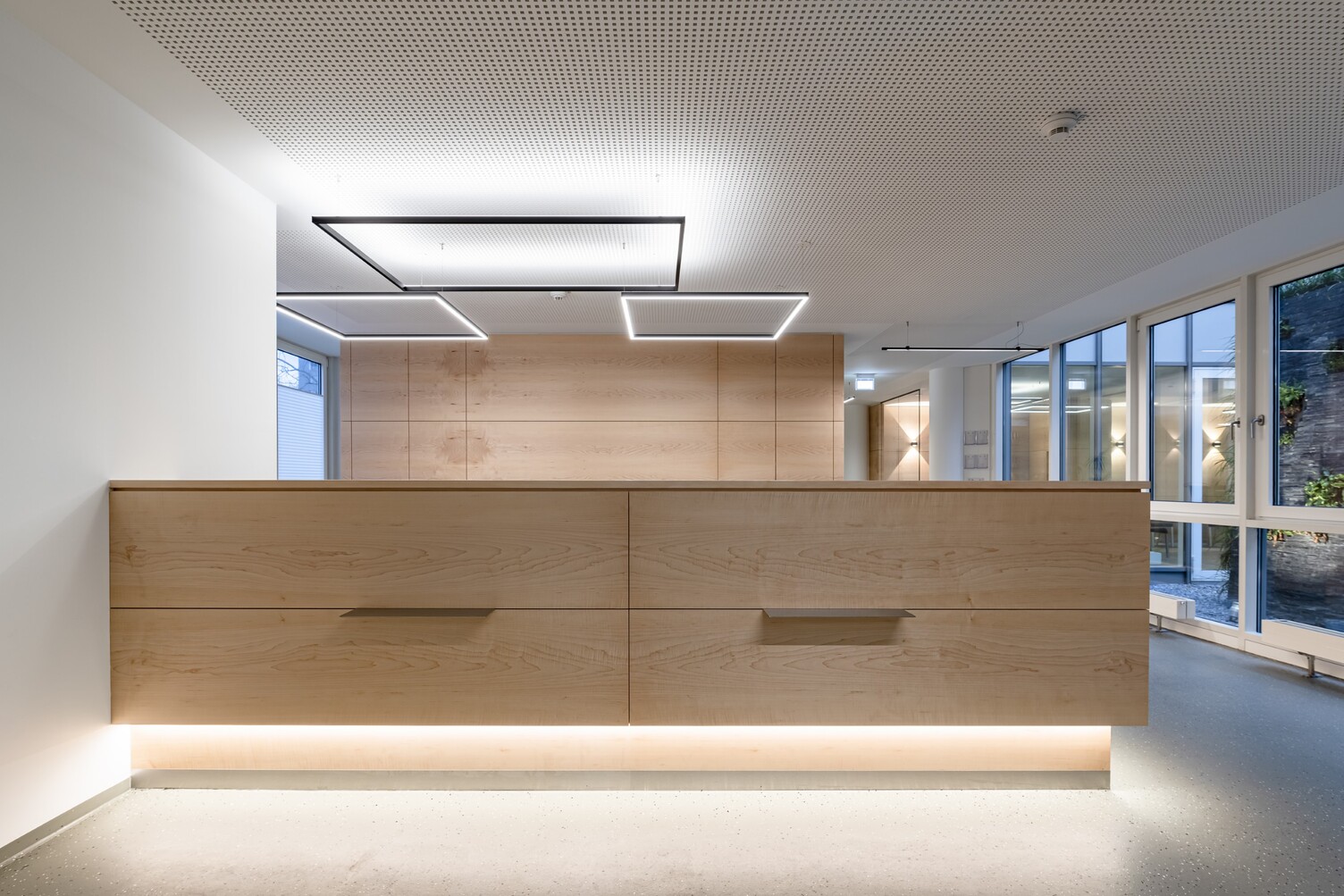 Beleuchtete Empfangstheke mit rechteckigen Lichtinstallationen | © ARCHITEKTURIMBILD, Bernhard Tränkle