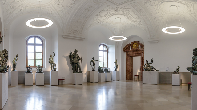Bronze hall of the Bavarian Palace Administration in the Munich Residence, exhibition room with bronze sculptures on white pedestals, ANELLO ring pendant luminaires with integrated spotlights are suspended from the stucco ceiling with its vaulted structure, illuminating the exhibits and the room. | © Bayerische Schlösserverwaltung, Residenz München