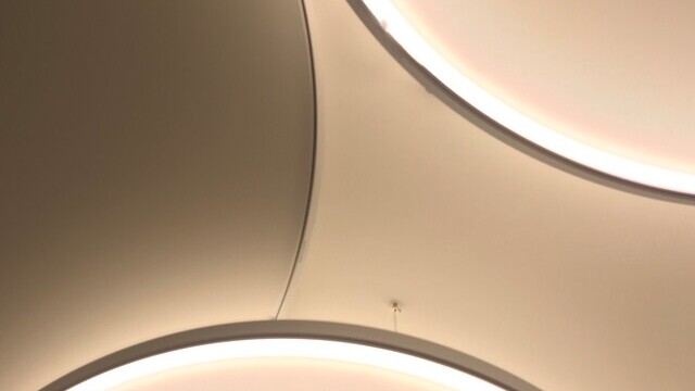 Detailsbiild einer Überschneidung von Acoustic Light Panel und Light Panel der Firma SATTLER von unten fotografiert.