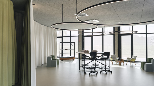 Verschiedene Doppio Direct / Indirekt Leuchten der Firma SATTLER in einem flexibel nutzbaren Bereich in einem Bürogebäude. Seien es Besprechungen, Arbeitsplätze oder Präsentationsflächen im New Work Konzept | ©  Christoph-Duepper