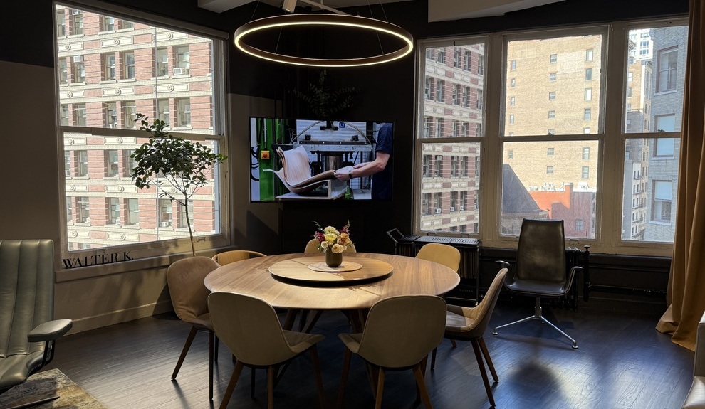 Ringleuchte DOPPIO leuchtet direkt und indirekt über rundem Esstisch Essraum mit großen Fenstern und Blick auf den Broadway, in der Mitte ein runder Esstisch mit Stühlen aus Holz von Walter Knoll. Über dem Tisch hängt eine Ringleuchte von SATTLER der Serie DOPPIO, die den Tisch erleuchtet und einen runden Rahmen für die Essecke gestaltet.