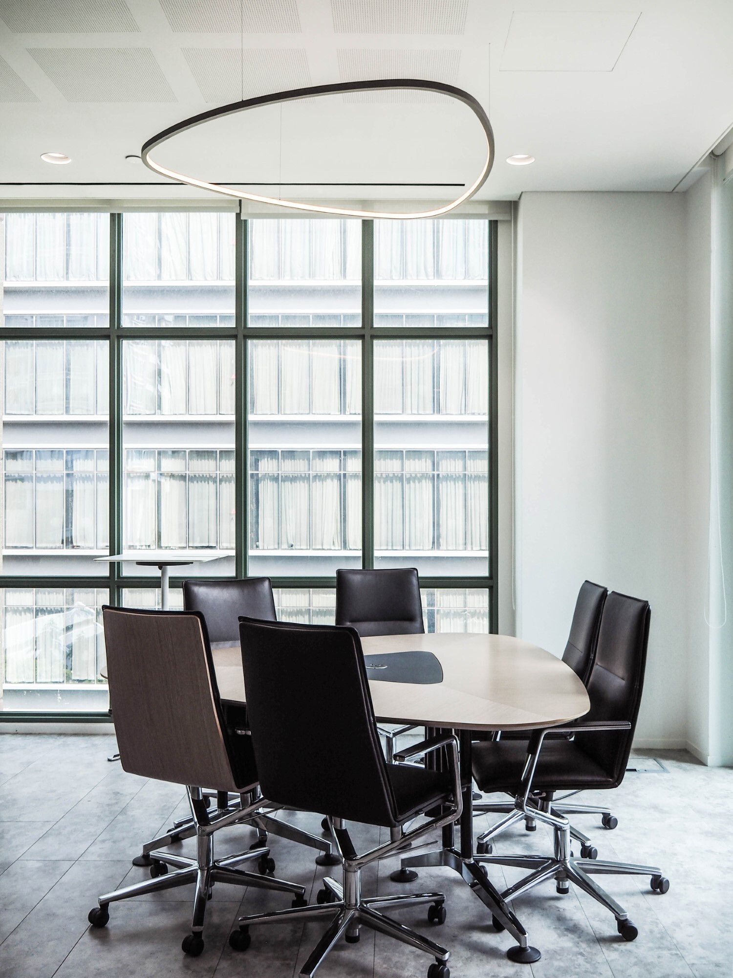 Slim Delta Pendelleuchte über einem Konferenztisch im Wilkhahn Showroom Singapur