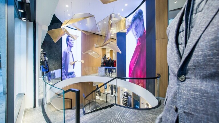 Sonderleuchten als mehrteilige Lichtinstallation mit geometrischen Lichtobjekten im Treppenbereich eines Retail Stores